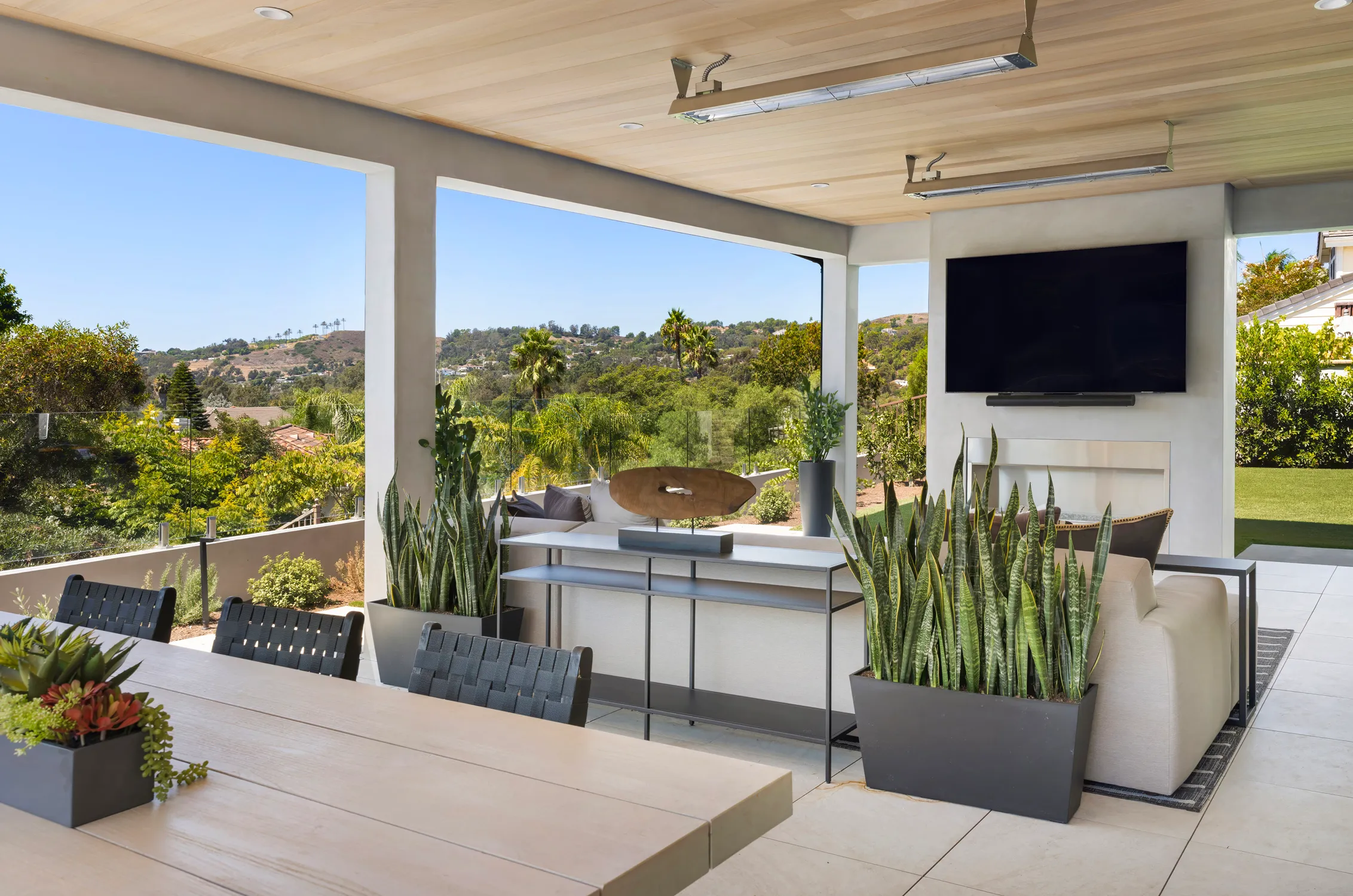 Covered patio with television and hillside view