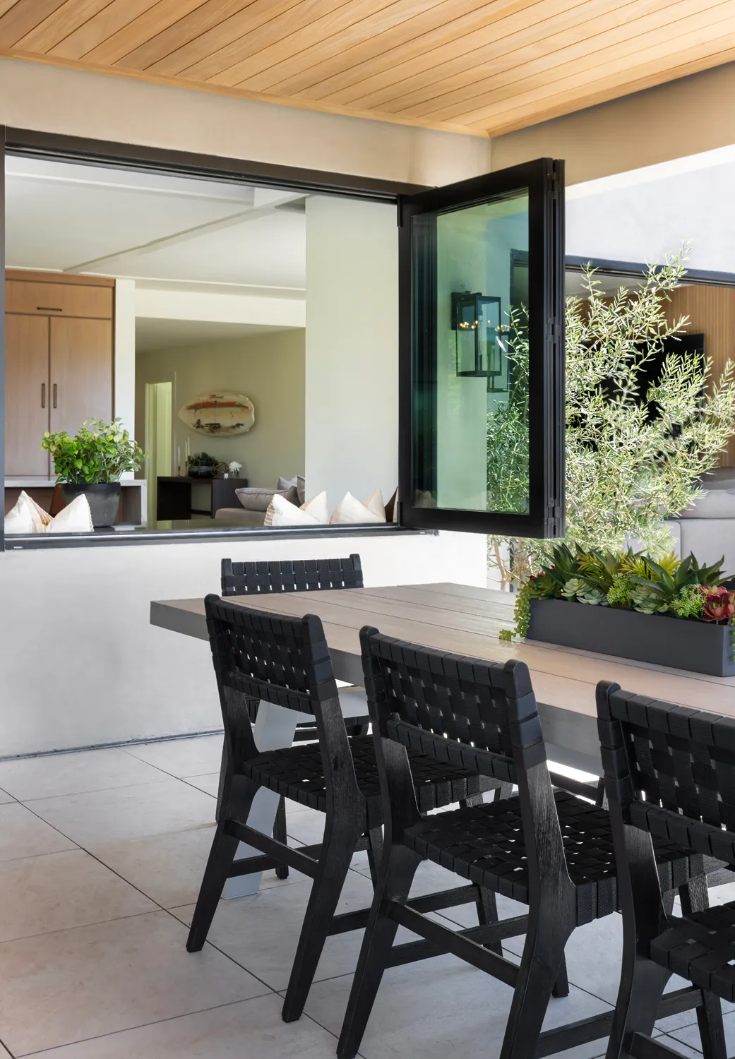 Outdoor dining table beside folding glass doors